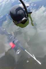 Man dressed as a hunter with an underwater scuba gun.