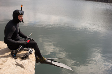 Man dressed as a hunter with an underwater scuba gun.