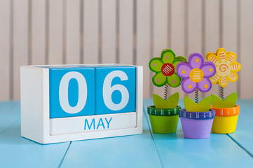 May 6th. Image of may 6 wooden color calendar on white background with flowers. Spring day, empty space for text