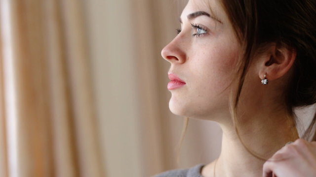 Attractive young woman with beautiful blue eyes thinking about something very important for her work at home.