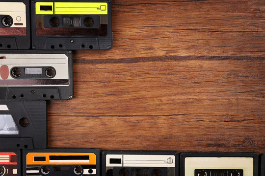 Collection of audio cassettes on wooden table, copy space