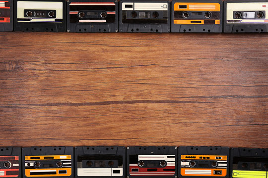 Group of audio cassettes on wooden table, copy space