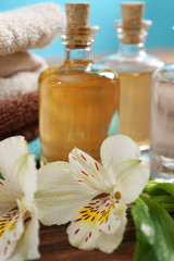 Fototapeta na wymiar Spa set: soft towel, flowers, massage oil, candles, sea salt, close up