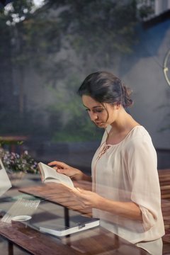 Businesswoman reading a book at desk