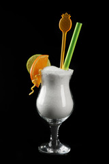 Hurricane glass with granulated sugar, cocktail tube and citrus slices on black background