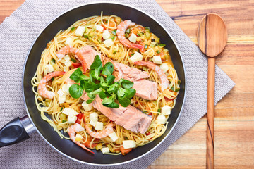 pasta with shrimp, tomato and sauce on a plate. Top view