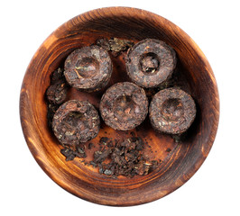 Dry pressed puer tea in saucer isolated on white