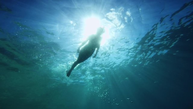 Bottom perspective woman swimming on surface of the caribbean islands of San Blas, Panama