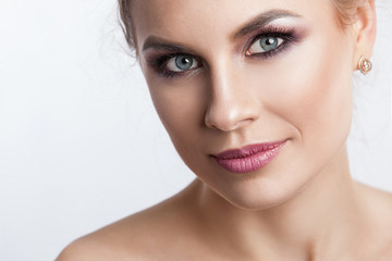 Fototapeta premium Beauty model girl with perfect make-up isolated over white. Portrait of attractive young woman with blond hair on white background. Beautiful female face with clear fresh skin
