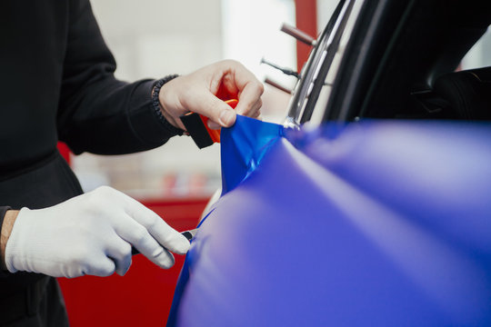 Man Wrapping Car With Vinyl Foil