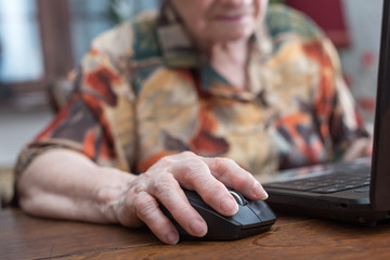 Senior hand using the mouse of a computer