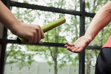 Athlete passing a baton to the partner