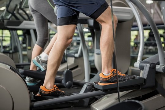 Woman and man exercising on the elliptical machine
