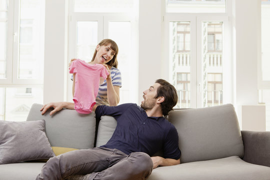 Expectant parents with pink baby shirt