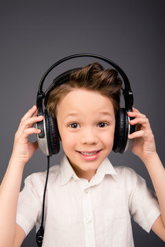 Portrait of little cute boy listening music in head-phones