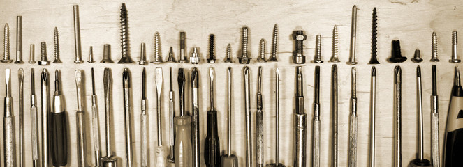 Many old fashioned screwdrivers and various screws