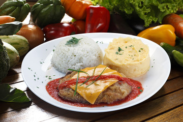 The steak parmigiana with potato and rice