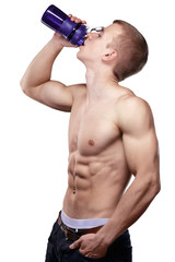 muscular man drinks water on a white background