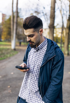 Young man looking at his smartphone in the park