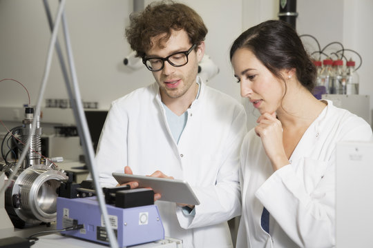 Scientists Working With Tablet Computer In Analytical Laboratory