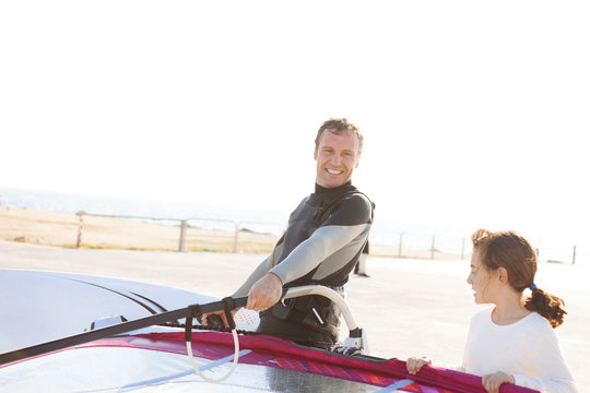 Smiling man with daughter at the coast with surfboard - Powered by Adobe