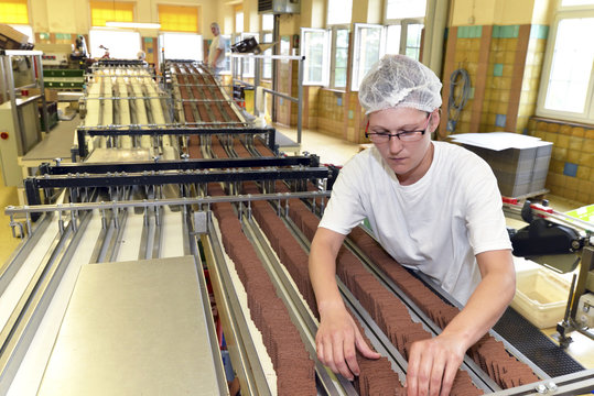 Germany, Saxony-Anhalt, woman working at production line in a baking factory