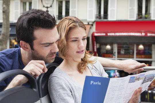 France, Paris, couple looking at a city map