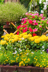 Beautiful flower garden on summer./ White picket fence surrounded by flowers in a front yard on summer.
