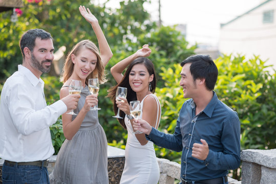 Multi-ethnic group of friends dancing at outdoor party