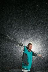 Silhouette of skier on backlit at night. Snowing