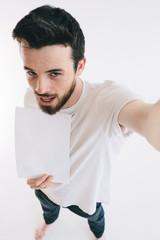 Bearded man holding a blank white sheet of paper