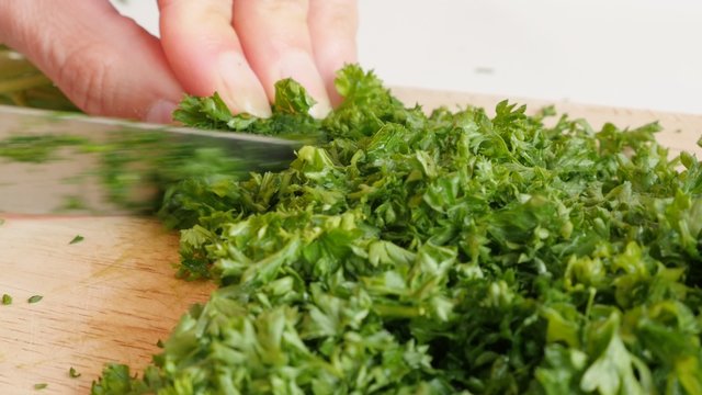 Green healthy vegetable  parsley cutting on smaller pieces 4K 3840X2160 UltraHD  footage - Petroselinum crispum plant on cutting board 4K 2160p UHD video