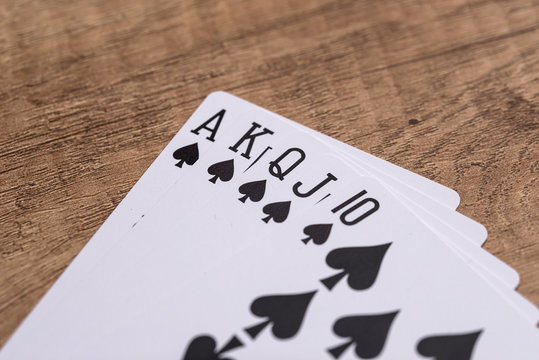 Set of Spade suit playing cards on wooden desk