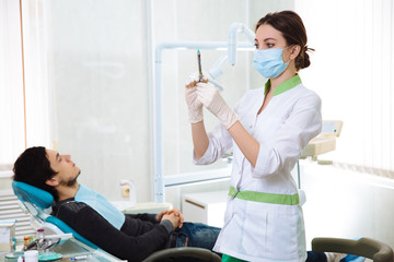 Dentist woman doing the procedure in the dental office