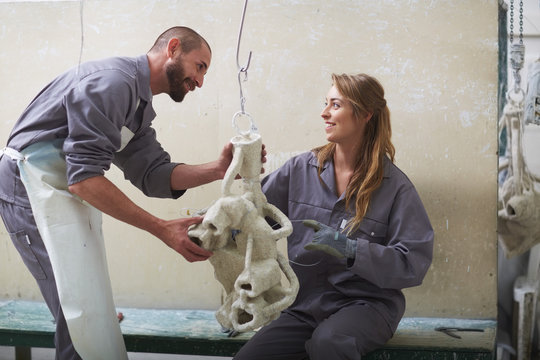 South Africa, Cape Town, Craftspeople preparing ceramic shell around casting mold