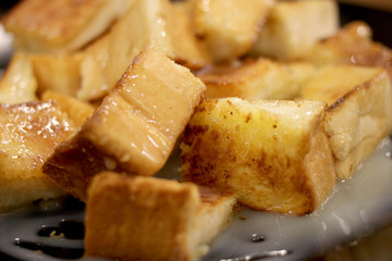 Bread toast with butter and condensed milk in a plate, select focus