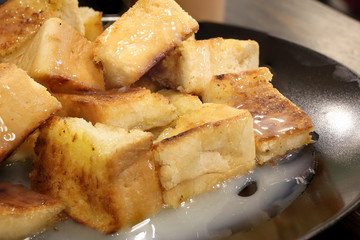Bread toast with butter and condensed milk in a plate, select focus