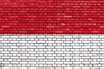 Fototapeta na wymiar flag of Monaco painted on brick wall