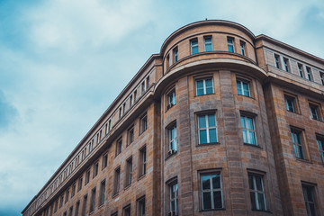 Obraz premium Old Brown Stone Building with Blue Sky and Clouds