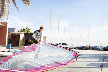 Man at car park holding surfboard
