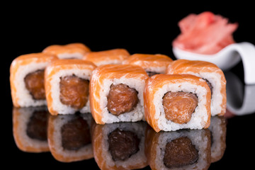 Sushi Roll with salmon over  black background with reflection