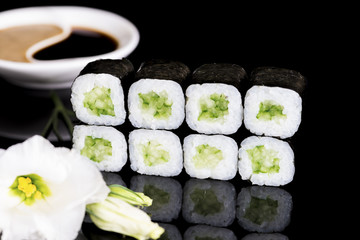 Sushi Roll with cucumber over  black background with reflection