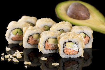 Sushi Roll with salmon and avocado over  black background with r