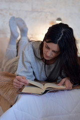 woman reading a book in bed