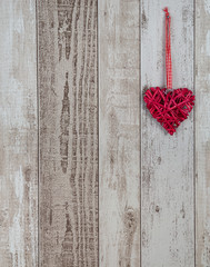 Red wood heart hanging on rustic wooden background