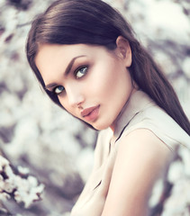 Spring fashion girl outdoors in blooming trees. Beauty romantic woman