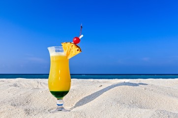 Fruity cocktail is on a beach