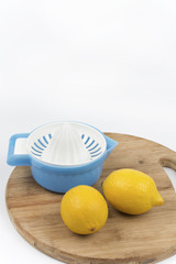 Two lemon and strainer on a wooden board