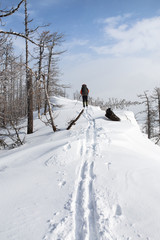 Naklejka na ściany i meble View of snow mountain and hiking man. Ski run in Ural mountains