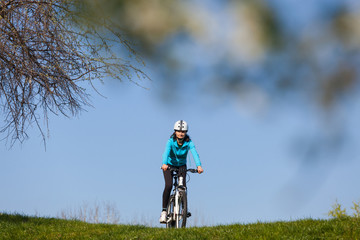 Obraz premium Woman riding a bike in the park